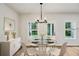 Chic dining area features a glass table, modern chandelier, and outdoor views at 241 Martin Spring Rd, Lawrenceville, GA 30045