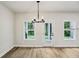 Dining area with wood floors, a modern chandelier, and access to the backyard at 241 Martin Spring Rd, Lawrenceville, GA 30045