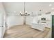 Open-concept living area with modern lighting, a fireplace, and a view of the kitchen, ideal for entertaining at 241 Martin Spring Rd, Lawrenceville, GA 30045