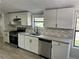 Updated kitchen with white cabinets, stainless steel appliances, and gray backsplash at 106 Evergreen Trl, Cartersville, GA 30121