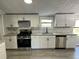 Updated kitchen boasting stainless steel appliances, custom backsplash, and contemporary fixtures at 106 Evergreen Trl, Cartersville, GA 30121