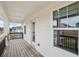 Covered balcony featuring wood decking, white columns, and view of nearby homes and surrounding landscape at 1270 Firefly Field Trce, Lawrenceville, GA 30045