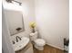 Compact half bathroom with a vessel sink, wood-look vanity, modern fixtures, and a decorative mirror at 2019 Chelton Se Way, Smyrna, GA 30080