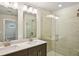 Modern bathroom with double vanity, quartz countertop, and glass-enclosed shower with tile surround at 4680 Hemingway Trl, Cumming, GA 30041