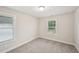 Bedroom with neutral walls and carpet boasts double windows that provide abundant natural light at 4680 Hemingway Trl, Cumming, GA 30041
