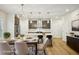 Dining room with modern lighting, an island with seating, and a dining table is virtually staged at 4680 Hemingway Trl, Cumming, GA 30041
