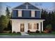 Charming two-story home with a brick facade, blue siding, black shutters, and a well-manicured lawn at 4680 Hemingway Trl, Cumming, GA 30041