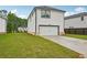 Rear exterior view of home featuring two-car garage and well-maintained lawn at 4680 Hemingway Trl, Cumming, GA 30041