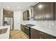 Kitchen boasts dark cabinetry, stainless steel appliances, marble backsplash, and quartz countertops at 4680 Hemingway Trl, Cumming, GA 30041