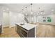 Island in an open concept kitchen with stainless steel appliances and modern light fixture at 4680 Hemingway Trl, Cumming, GA 30041