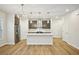 Modern kitchen with an island, stainless steel appliances, dark wood cabinets, and stylish pendant lighting at 4680 Hemingway Trl, Cumming, GA 30041