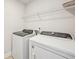 Bright laundry room featuring a white washer and dryer and wire shelving for storage at 4680 Hemingway Trl, Cumming, GA 30041