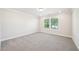 Spacious bedroom features plush carpeting, neutral paint, and a large window offering natural light at 4690 Hemingway Trl, Cumming, GA 30041
