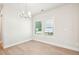 Bright dining room features wood floors, modern chandelier, and natural light from a window at 4690 Hemingway Trl, Cumming, GA 30041