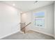 Bright hallway with carpet, natural light from the window, and access to the upper level at 4690 Hemingway Trl, Cumming, GA 30041