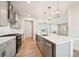 Modern kitchen with stainless appliances, large island, and open layout into living room at 4690 Hemingway Trl, Cumming, GA 30041