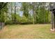 View of the large backyard, featuring a fenced area, mature trees, and lush green grass at 315 Mckees Rock Ln, Lawrenceville, GA 30044