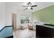 Bright bedroom featuring wood floors, neutral walls, ceiling fan, and large windows with treetop views at 5523 Glenridge Ne Park, Atlanta, GA 30342