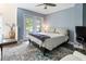Bedroom with blue walls, wood floors, ceiling fan, and a sliding glass doors leading to a porch at 5523 Glenridge Ne Park, Atlanta, GA 30342
