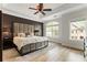 Elegant main bedroom features tray ceiling, hardwood floors, a plush bed and ample natural light from large windows at 5523 Glenridge Ne Park, Atlanta, GA 30342