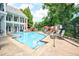 A refreshing community pool with lounge chairs, umbrellas, and well-maintained landscaping and nearby seating at 5523 Glenridge Ne Park, Atlanta, GA 30342