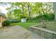 Expansive backyard with lush greenery, mature trees, and a storage shed surrounded by landscaping at 698 N Superior Ave, Decatur, GA 30033