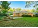 Well-maintained backyard with a brick home, green grass, and mature trees offering ample shade at 698 N Superior Ave, Decatur, GA 30033