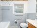 Neutral bathroom featuring tiled walls, gray tiled floors, a toilet, and a window at 698 N Superior Ave, Decatur, GA 30033