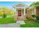 Charming brick home showcasing a covered front entrance with a bright red door and manicured lawn at 698 N Superior Ave, Decatur, GA 30033