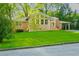 Quaint brick home surrounded by mature trees and lush greenery, featuring a well-manicured lawn and convenient carport at 698 N Superior Ave, Decatur, GA 30033