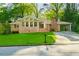 Charming brick home with a well-manicured lawn, a driveway with a carport, and mature trees providing ample shade at 698 N Superior Ave, Decatur, GA 30033