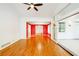 Spacious living room with hardwood floors, red accent wall, and expansive sliding doors to a sunroom at 698 N Superior Ave, Decatur, GA 30033