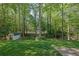Lush green backyard with mature trees and shed providing a private and serene outdoor space at 1569 Chateau Dr, Dunwoody, GA 30338