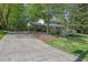 Beautiful two-story home with brick facade, black shutters, and long driveway leading to the property at 1569 Chateau Dr, Dunwoody, GA 30338
