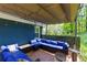 Covered patio boasts stylish blue seating, lighting and a tranquil view of lush greenery at 2673 Rainbow Forest Dr, Decatur, GA 30034