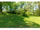 Well-manicured backyard features mature trees and a lush green lawn, perfect for outdoor activities at 2673 Rainbow Forest Dr, Decatur, GA 30034