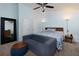 Bright bedroom featuring a queen size bed, ceiling fan, seating area, and plush carpeting at 2673 Rainbow Forest Dr, Decatur, GA 30034