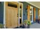 A natural wood front door with glass panes, complemented by charming wooden shutters and potted plants at 2673 Rainbow Forest Dr, Decatur, GA 30034