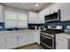 Well-lit modern kitchen with stainless steel appliances and stylish blue tile backsplash at 2673 Rainbow Forest Dr, Decatur, GA 30034