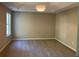 Spacious bedroom featuring plush carpet, a modern light fixture, and a window at 4018 Dorchester Nw Walk, Kennesaw, GA 30144