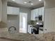 Kitchen view featuring granite countertops and white cabinets, open to adjacent rooms at 4018 Dorchester Nw Walk, Kennesaw, GA 30144
