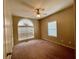 Spacious bedroom featuring a large arched window, ceiling fan and neutral decor at 25 Derby Dr, Hiram, GA 30141