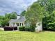 Single story home featuring a stone facade, covered porch, lush front lawn, and mature trees at 25 Derby Dr, Hiram, GA 30141