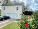 Two story home with vinyl siding, a three-car garage, and beautiful rose bushes in the front yard at 25 Derby Dr, Hiram, GA 30141