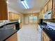 A kitchen with light colored cabinets, black countertops, and tile flooring extending to the dining area at 25 Derby Dr, Hiram, GA 30141