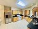 A kitchen with light colored cabinets, tile floors, a stainless steel refrigerator, and black countertops at 25 Derby Dr, Hiram, GA 30141