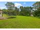 Large backyard features a trampoline and a view of the surrounding trees at 1230 Brook Meadow Ct, Lawrenceville, GA 30045