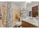 Functional bathroom featuring a shower and tub, sink, toilet, and storage shelves at 1230 Brook Meadow Ct, Lawrenceville, GA 30045