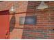Exterior brick building featuring an address sign, industrial lighting, and a red door at 1133 Church St # 6, Covington, GA 30014