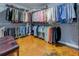 Spacious walk-in closet with custom shelving, hanging rods, and a comfortable bench for dressing with polished floors at 1133 Church St # 6, Covington, GA 30014